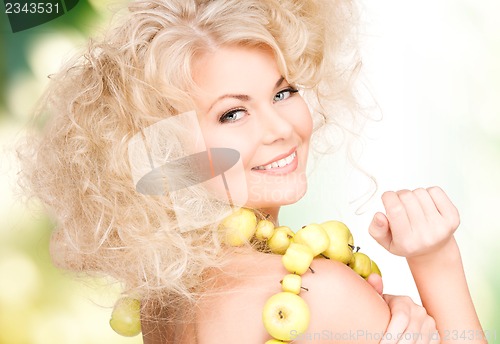 Image of happy woman with green apples