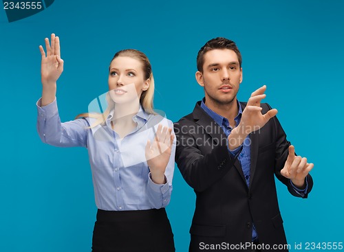 Image of man and woman working with something imaginary