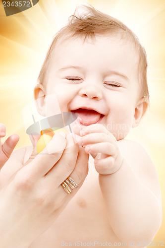 Image of laughing baby boy in mother hands with rubber duck