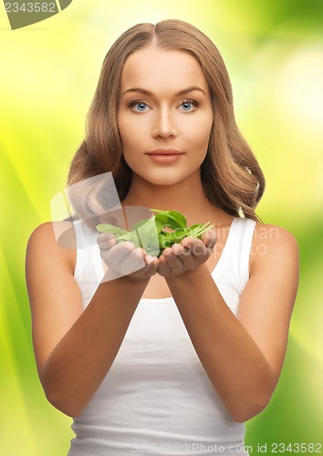 Image of woman with spinach leaves on palms