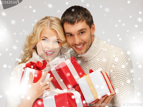 Image of romantic couple in a sweaters with gift boxes