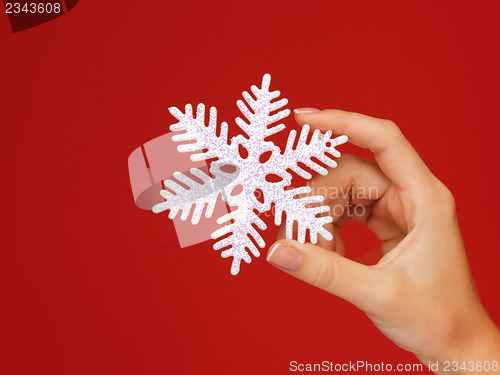 Image of woman's hands holding a snowflake