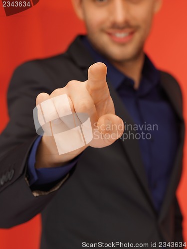 Image of handsome man in suit pressing virtual button