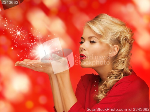 Image of woman blowing something on the palms of her hands