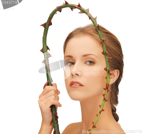 Image of woman holding branch with thorns