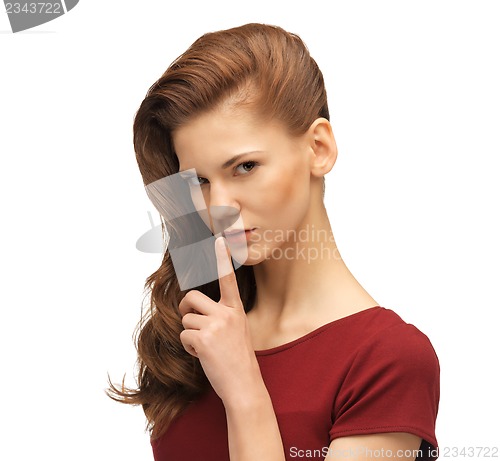 Image of teenage girl in red dress with finger on lips