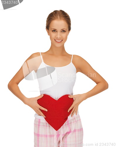 Image of happy and smiling woman with heart-shaped pillow