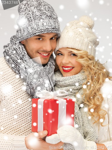 Image of romantic couple in a sweaters with gift box