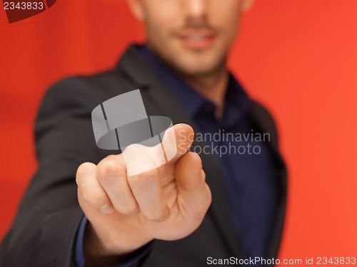 Image of handsome man in suit pressing virtual button