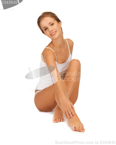 Image of woman in cotton undrewear touching her legs