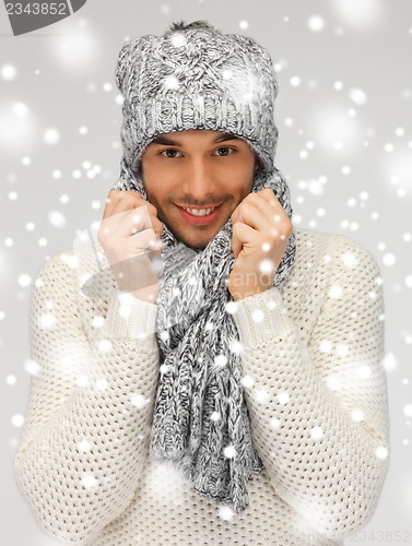 Image of handsome man in warm sweater, hat and scarf