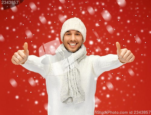 Image of handsome man in warm sweater with snow