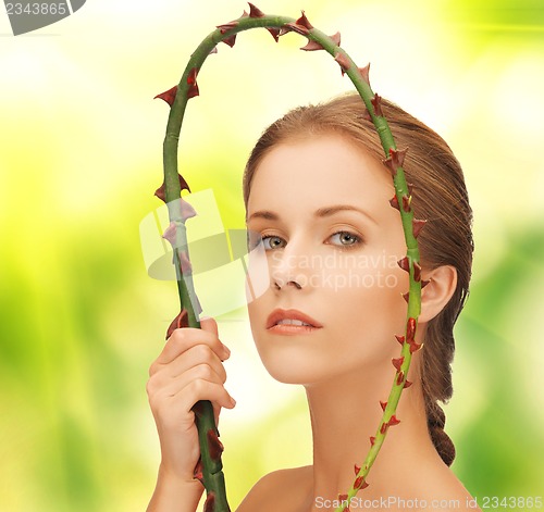 Image of woman holding branch with thorns