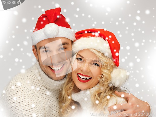 Image of family couple in sweaters and santa's hats