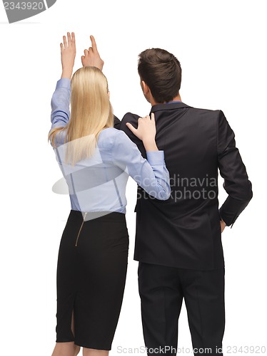 Image of man and woman working with something imaginary