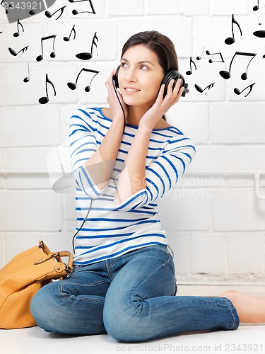 Image of happy teenage girl in big headphones