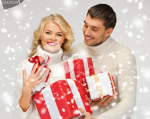 Image of romantic couple in a sweaters with gift boxes