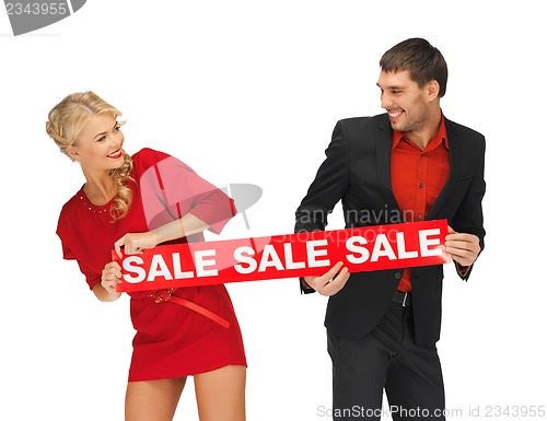 Image of man and woman with sale sign