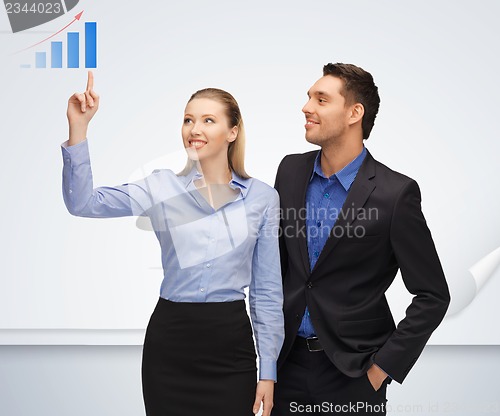 Image of man and woman pointing their fingers to chart