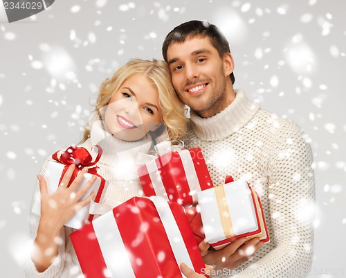 Image of romantic couple in a sweaters with gift boxes