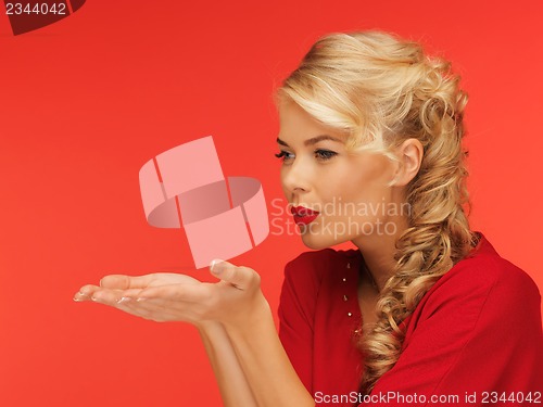 Image of woman blowing something on the palms of her hands