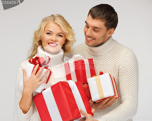 Image of romantic couple in a sweaters with gift boxes