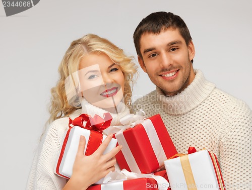 Image of family couple in a sweaters with gift boxes