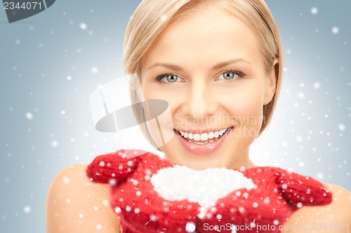 Image of beautiful woman in red mittens with snow