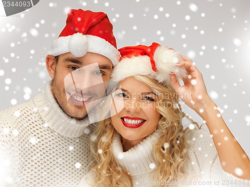 Image of family couple in sweaters and santa's hats