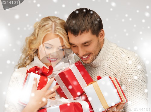 Image of romantic couple in a sweaters with gift boxes