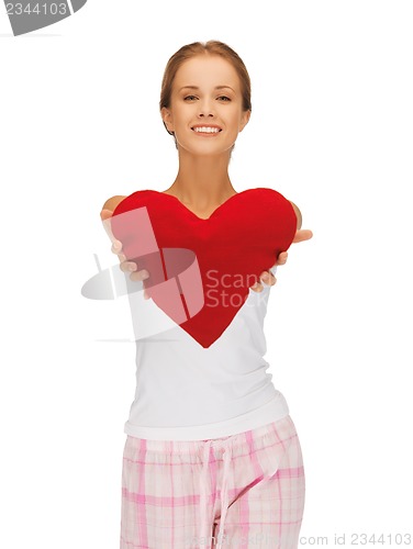 Image of happy and smiling woman with heart-shaped pillow