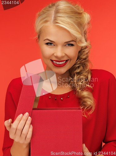 Image of lovely woman in red dress with opened gift box