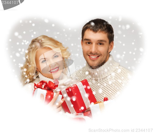 Image of family couple in a sweaters with gift boxes