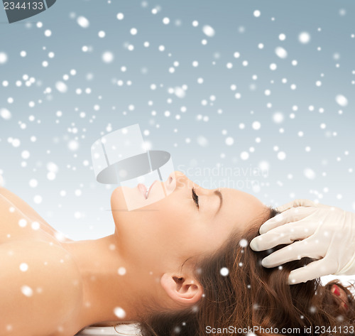 Image of beautiful woman in massage salon with snow