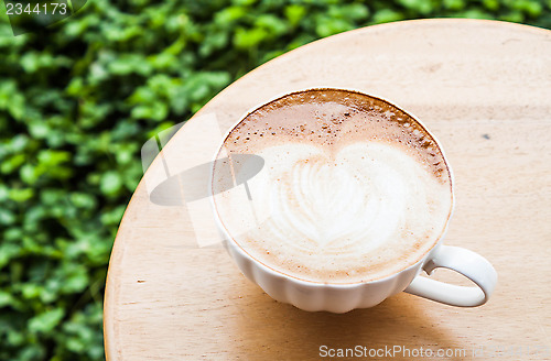 Image of Free pour hot coffee latte serving on wood table