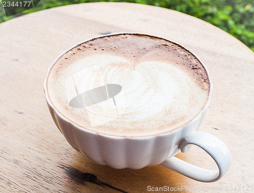 Image of Free pour hot coffee latte cup serving in garden