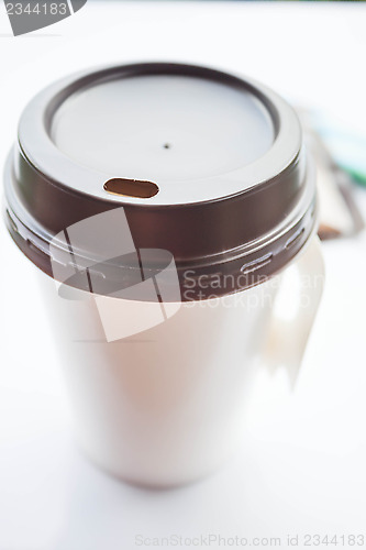 Image of Coffee in paper cup with sugar packs on white background