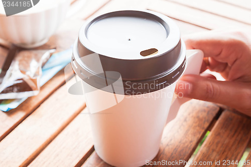Image of Hot coffee in paper cup serving on wood table