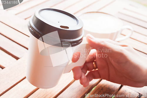 Image of Hot coffee in paper cup serving at coffee shop