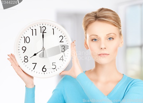 Image of businesswoman with wall clock