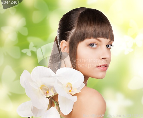 Image of beautiful woman with orchid flower and butterflies