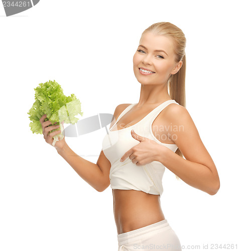 Image of sporty woman with lettuce showing abs