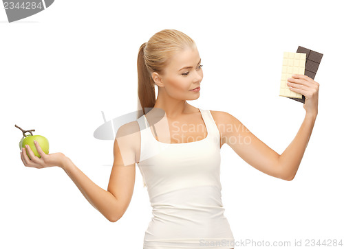 Image of sporty woman with apple and chocolate bars