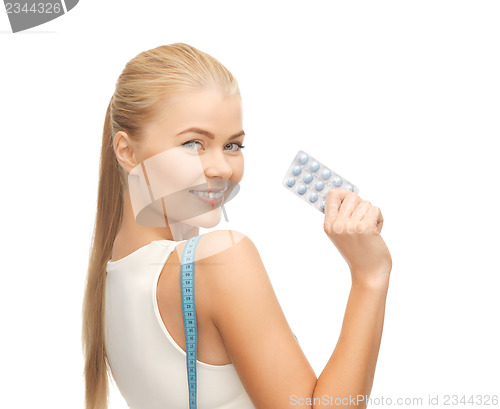 Image of woman with measuring tape and diet pills