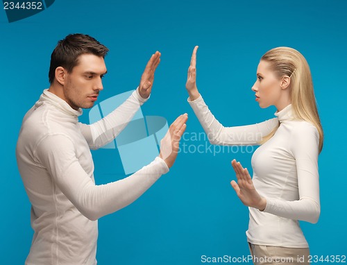 Image of man and woman working with something imaginary