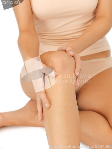 Image of hands touching knee