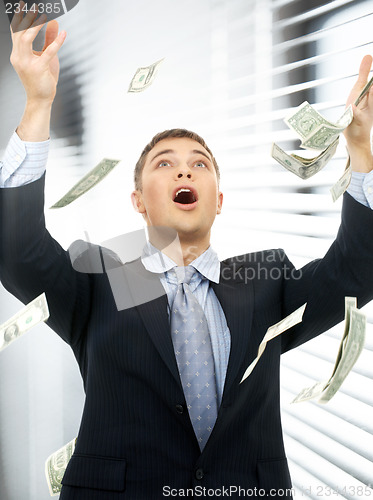 Image of businessman in money rain indoors