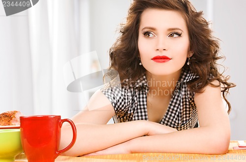 Image of young attractive woman in the kitchen