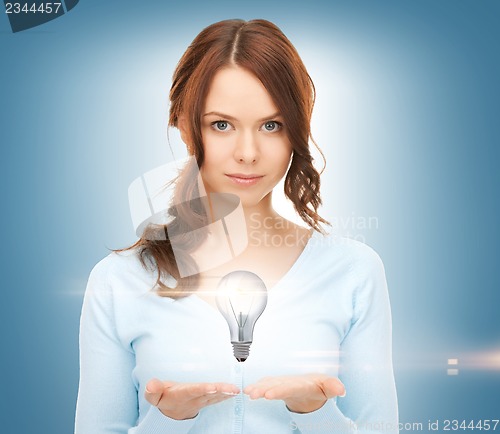 Image of woman showing light bulb on the palm of her hands