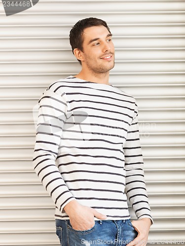 Image of handsome man in casual clothes leaning to wall